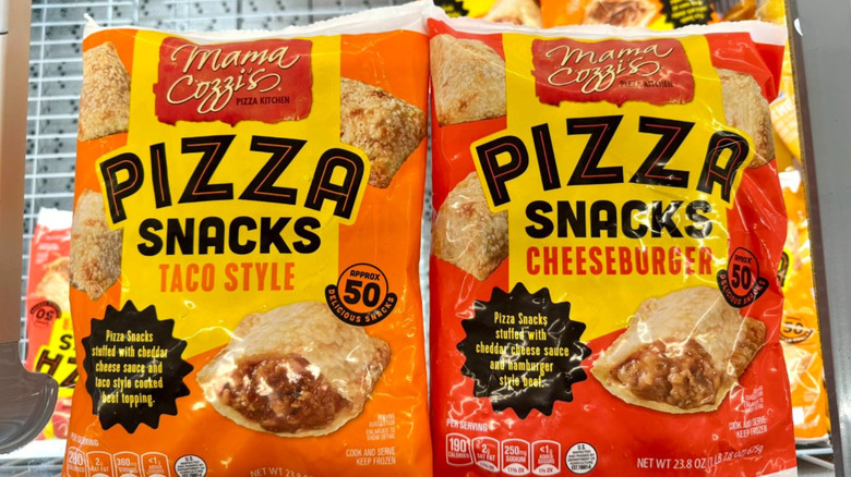 Two bags of Mama Cozzi's Pizza Snacks sit in a cart, a Taco flavor and a Cheeseburger flavor