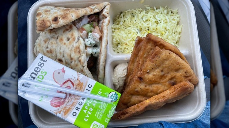 Cava kids meal with filled pita, rice, pita chips with hummus, and a juice box