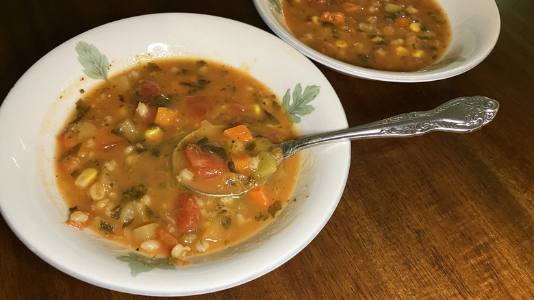 two bowls of Cedar Lane Organic Chopped Vegetable & Barley Soup full of vegetables in a tomato broth