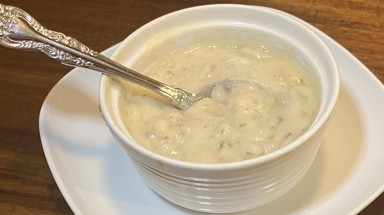 closeup of a bowl of potato soup with a spoon sticking out of it