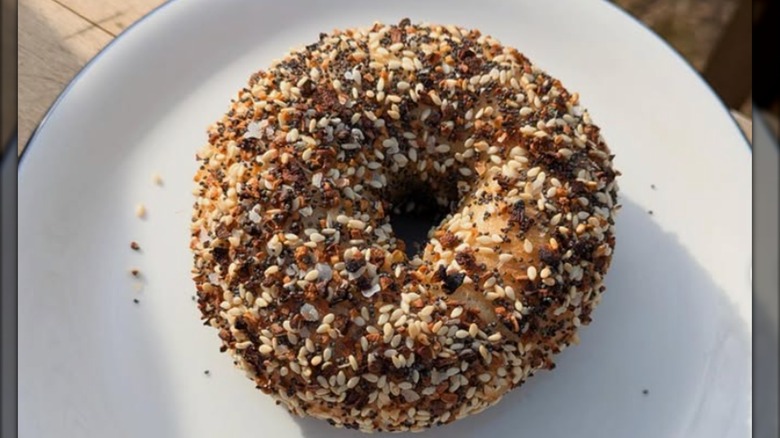 Spicy everything bagel on a white plate, overhead view, at Blue House Bagels