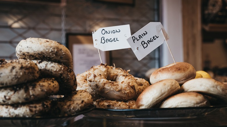 Close up of a variety of bagels on sale, including plain and onion flavors