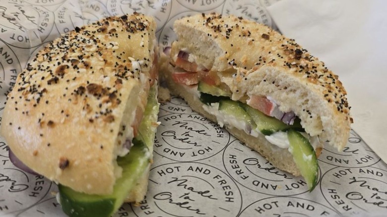 Everything bagel with cream cheese and veggies on wax paper from Mort's Bagels