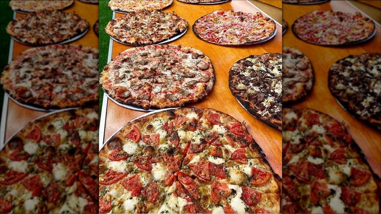 Assorted thin crust New Haven-style pizzas on a wooden table