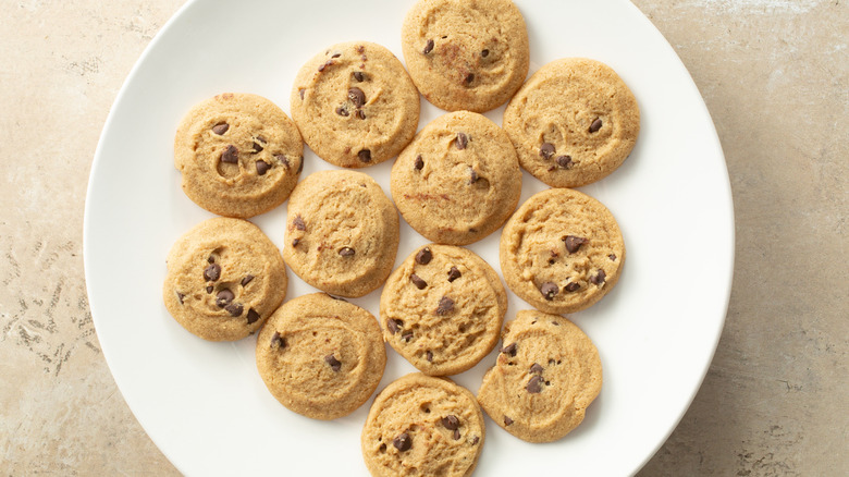 Gluten-free chocolate cookies sit on a white ceramic plate.
