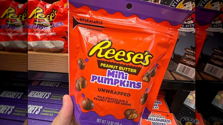 hand holding bag of Reese's mini pumpkins