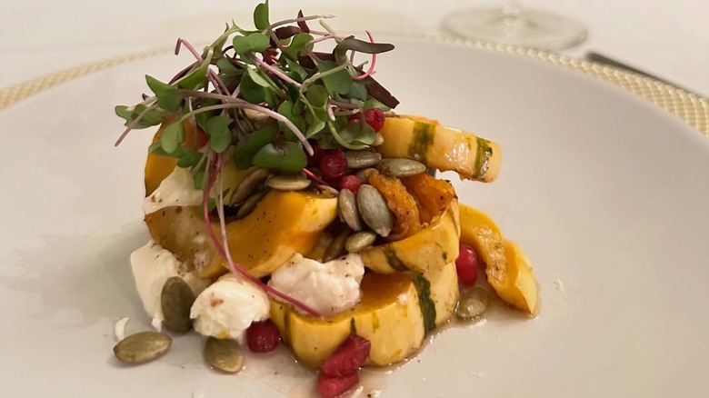 Burrata with squash, seeds, and greens garnish from Amalia's Authentic Italian Restaurant in North Carolina