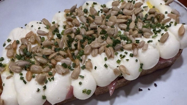 Sourdough toast topped with red onion jam, a ricotta mascarpone topping with sunflower seeds from iggy's restaurant in Tennessee