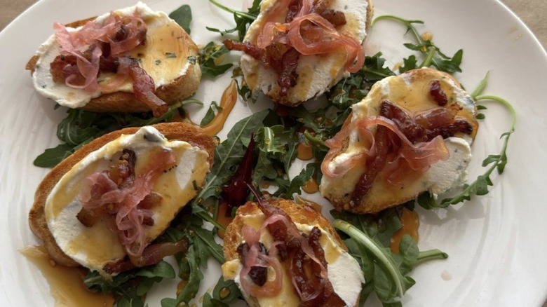 Crostini topped with whipped ricotta, guanciale, pickled red onion, and hot honey drizzle from Pazzo Pastaria restaurant in Texas