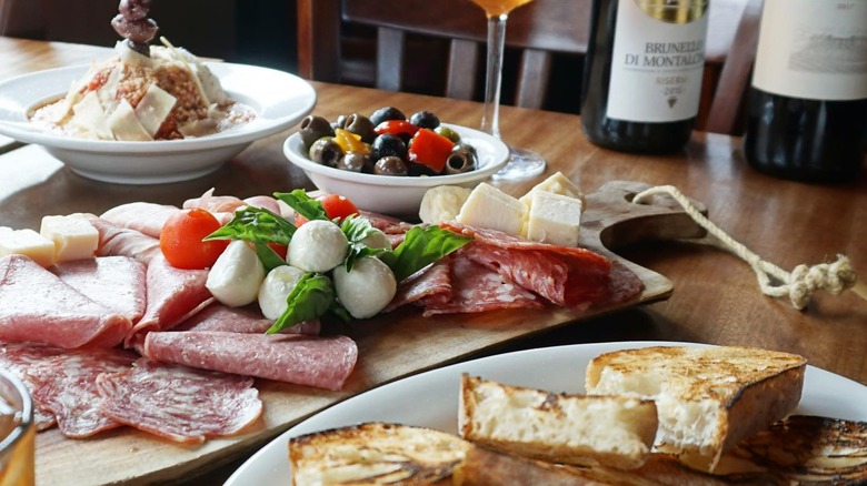 Charcuterie with fresh mozzarella, a pasta dish with fresh cheese, and sliced toast on a table at Santino's Little Italy restaurant in Milwaukee