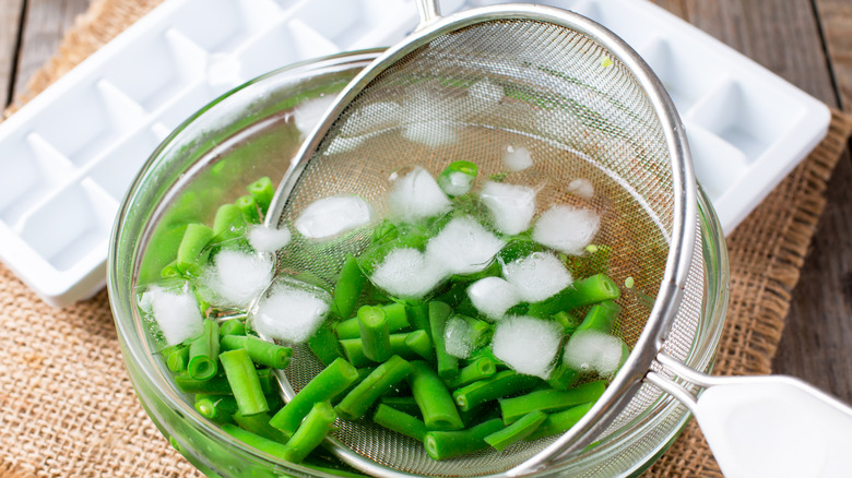 Blanched green beans in ice water.