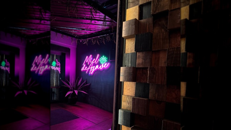 Miel De Agave's interior dining room with neon lit sign