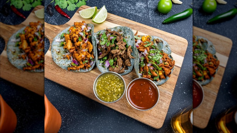 Taco Empire mexican dishes on wooden cutting board with fresh limes