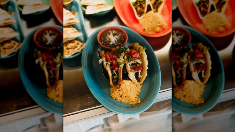 Platse of Uno Mas Tex Mex tacos, beans, and rice ready to be delivered to tables