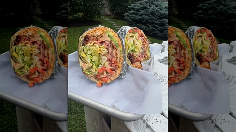 Close up of a burrito from The Avocado Pit, cut in half to show fillings