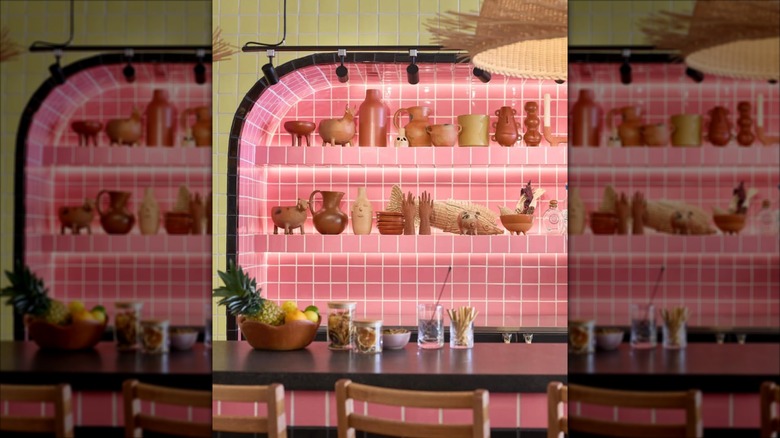 The interior bar of Lolita's, featuring a pink tile wall and shelves of pottery