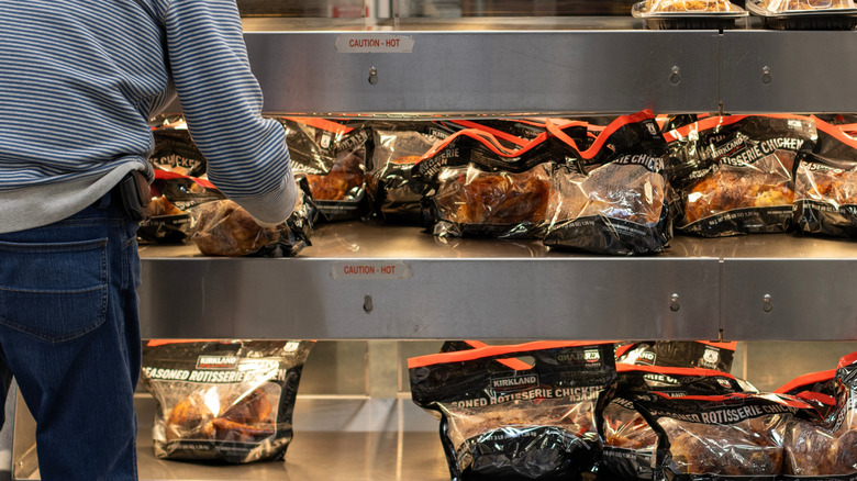 packaged rotisserie chicken under heat lamp at grocery store