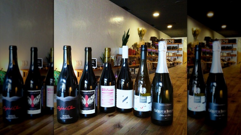 Six bottles of wine on a wooden bar top at Le Bois Wines
