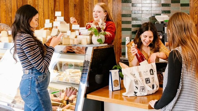 Workers and customers at the cheese counter at All Together Now