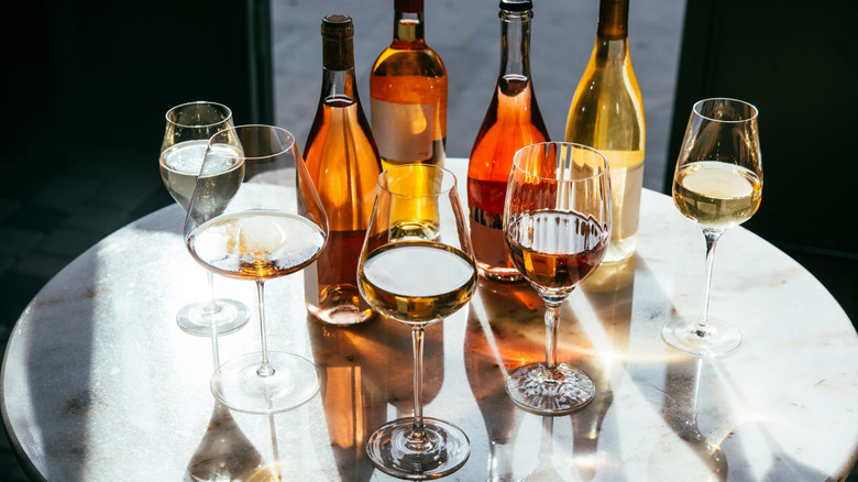 Assorted bottles and glasses of wine on a round white table