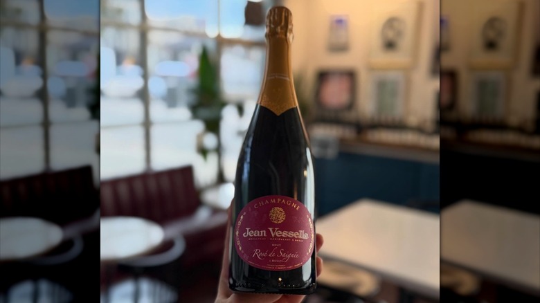 Hand holding a bottle of Champagne at Nouvelle Bar & Bottle