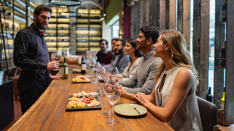 Bartender talking with patrons at wine bar