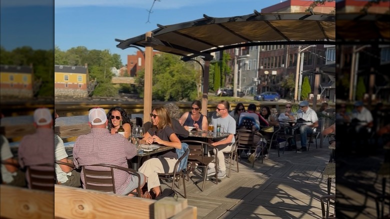 People sitting outside drinking wine on the deck at Vino e Vivo