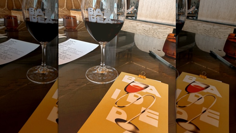 Glass of red wine and menu on a table at Bad Idea