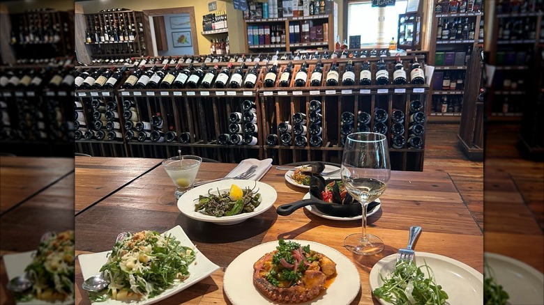 Various plates of food and racks of wine bottles at Bin22