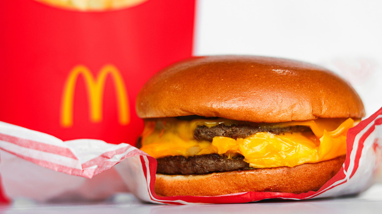 Close up of a McDonald's double cheeseburger with the packaging behind it