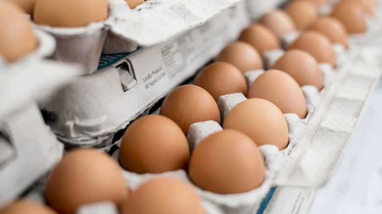 Many cartons of eggs on display with eggs visible.