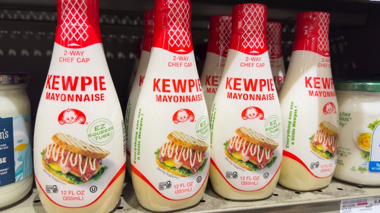 A store shelf with four rows of kewpie mayonnaise on it