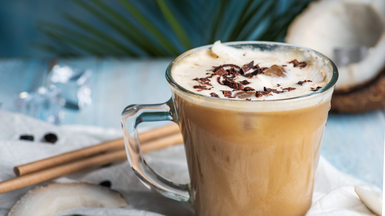 A coconut milk latte with a coconut in the background.