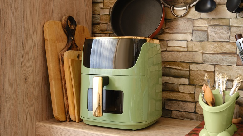 A green air fryer on a kitchen counter