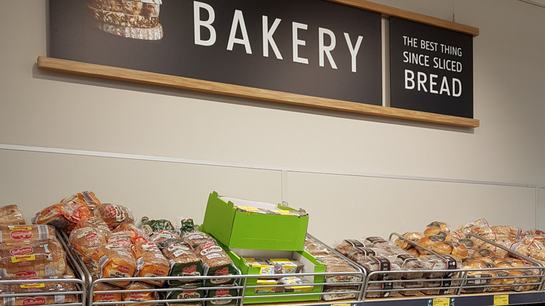 The bakery section at Aldi with bread in boxes and the bakery sign at the top of the shot