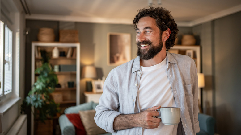 A happy man holding a cup of coffee