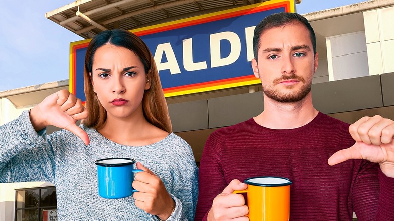 Two angry people display thumbs down holding coffee cups in front of Aldi