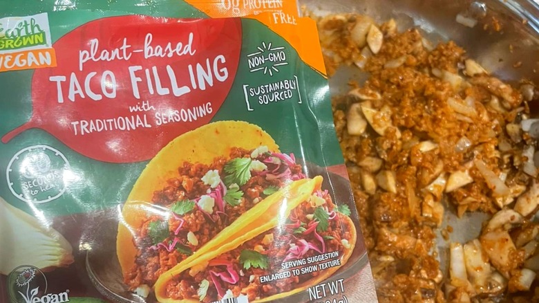 A closeup of Aldi's plant-based taco filling package with the prepared product behind it