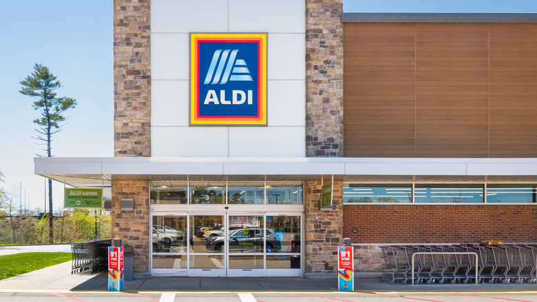 An Aldi storefront with a sign and shopping carts