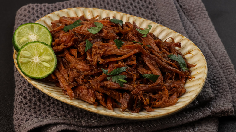 Barbacoa sitting on a plate with lime slices