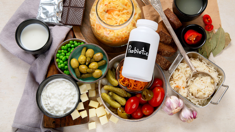 A tray of fermented and probitoic foods, including pickles, cottage cheese, sauerkraut, and kefir