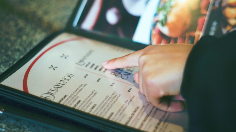 Finger pointing to item on restaurant menu
