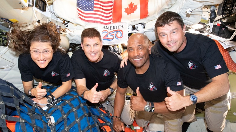 The crew of Artemis II giving thumbs up in space
