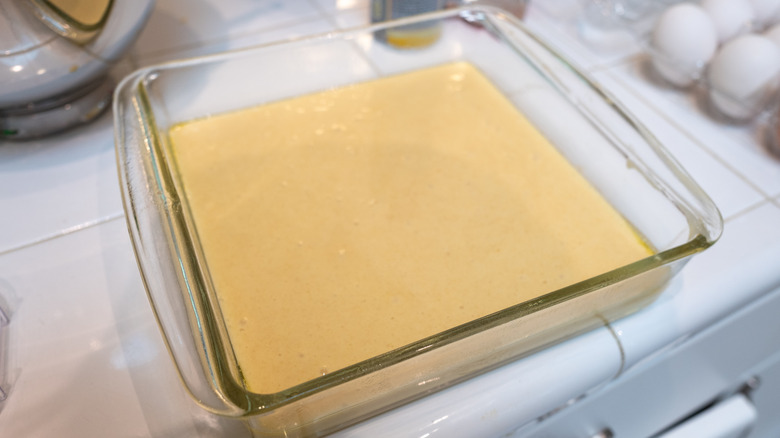 yellow cake batter in a pyrex baking pan