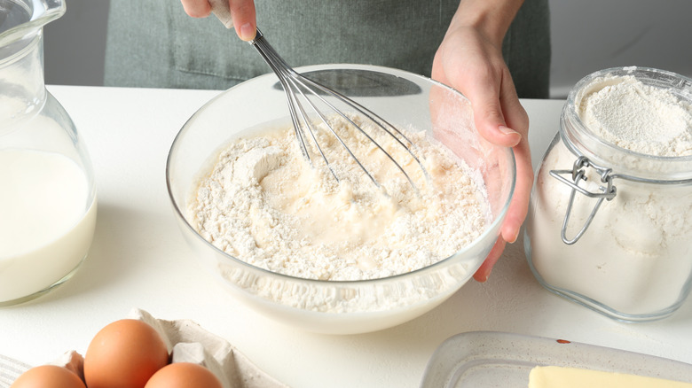 hands stirring cake batter in a bowl