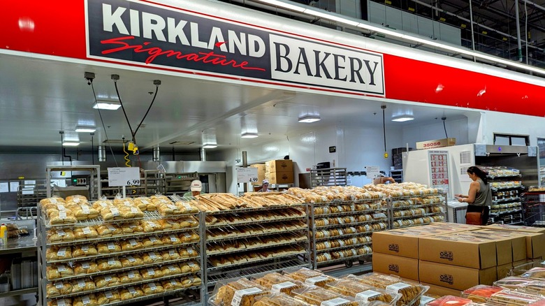 Costco bakery section with shopper standing in front of rolls of bagels