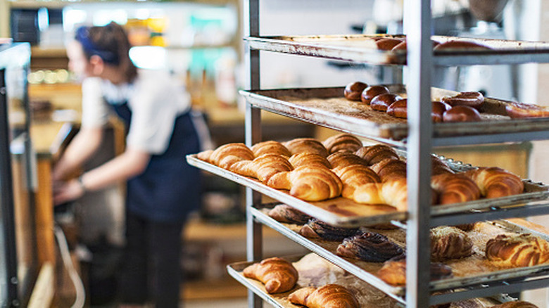Fresh pastries on trays inside of a bakery during the day