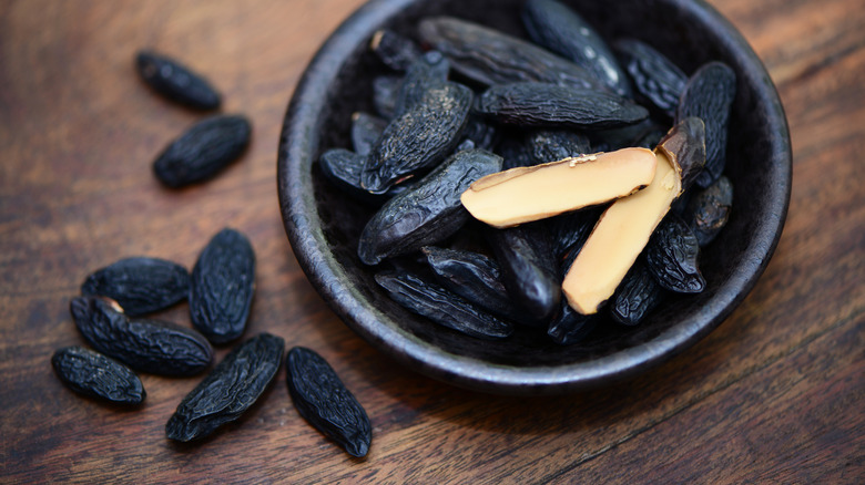 Tonka beans in a rustic bowl on a wooden table