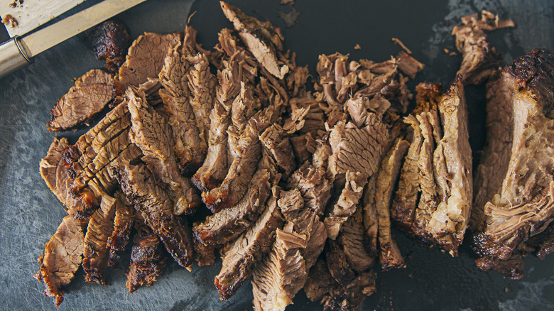 sliced smoked brisket on a black surface