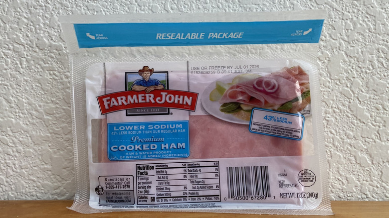Package of Farmer John ham propped up on a wooden table